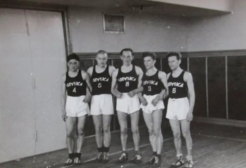 Viis korvpallurit LIIVIKA kirjaga särkides spordisaalis, mustvalge foto