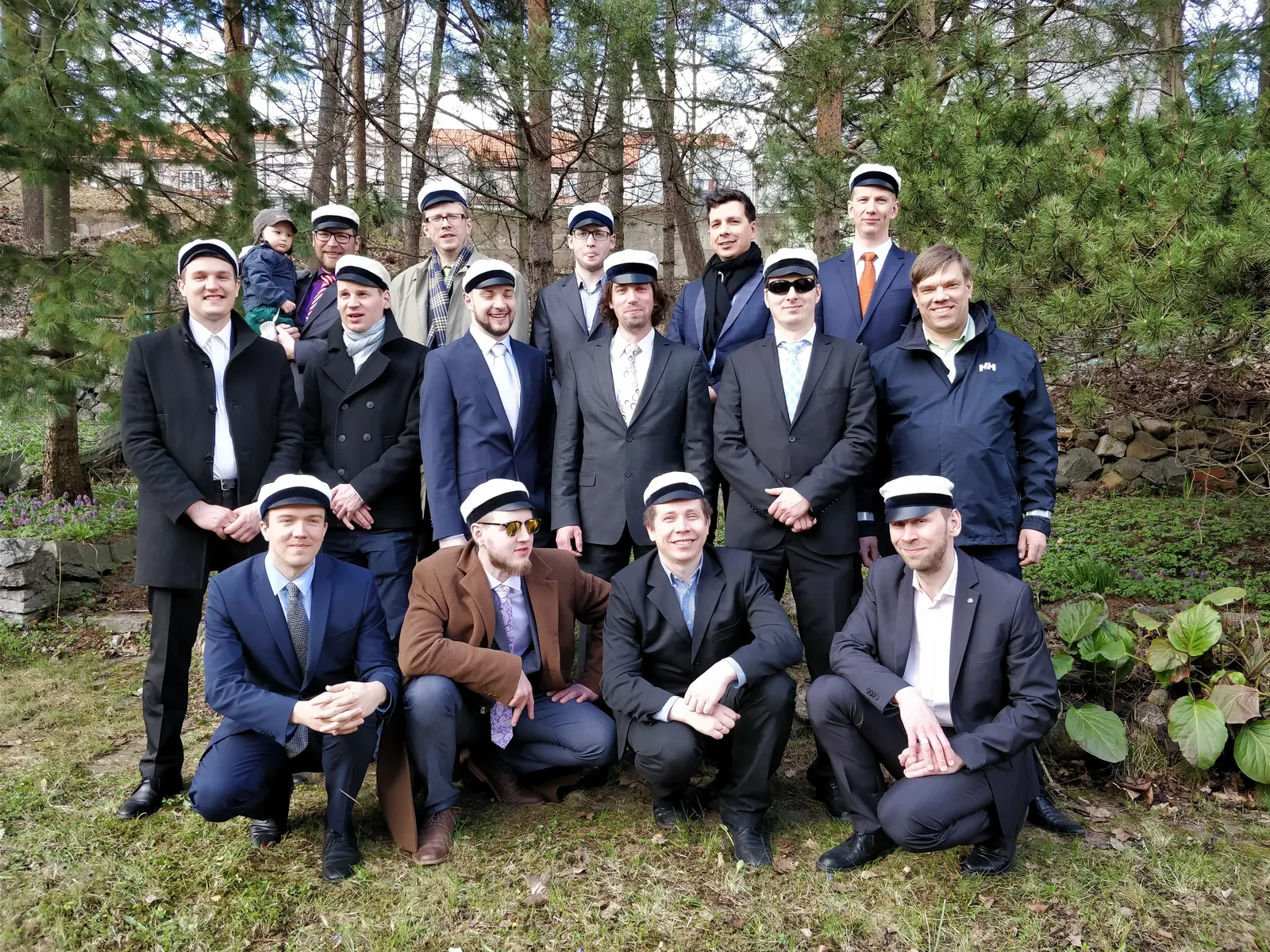 Liiviklased valgetes üliõpilasmütsides grupipildil seltsi aias, mustvalge foto